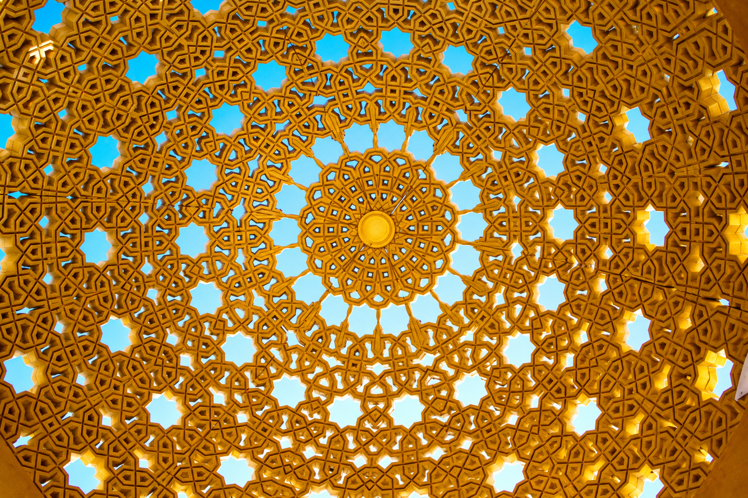 Gold geometric lattice viewed against the sky